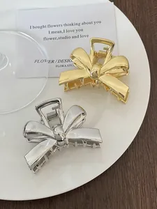 Detailed view of polished gold and silver alloy bow hair clips in a stylish setup