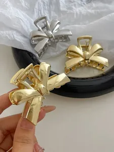Detailed view of elegant gold and silver alloy bow hair clips with spring metal claws