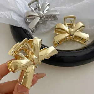 Elegant gold and silver bow-shaped alloy hair claws with a minimalist metal design