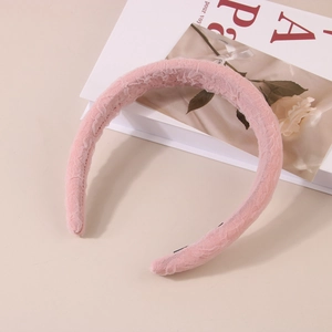 Gros plan sur la dentelle rose et la structure rembourrée de ce serre-tête chic