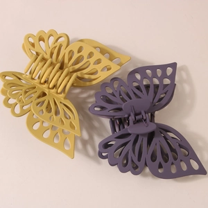 Detail view of large hollow butterfly hair claws in matte ginger and lilac resin