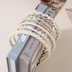 Detail view of pearl headband collection with gold metal chain and woven pearl designs