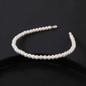 Detailed shot of white pearl headband featuring round beads on a slim metal base
