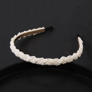 Detailed side view of pearl headband with golden base on minimalist black background