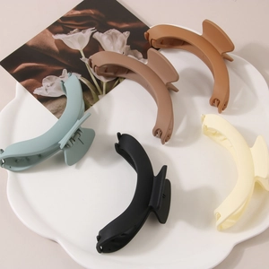 Detail view of large matte geometric hair claws in five elegant neutral tones for women