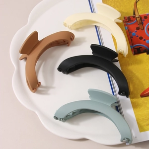 Large matte geometric hair claws in cream, brown, black and blue in a decorative tray