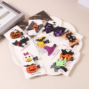 Detail shot of Halloween hair clips featuring pumpkin and ghost motifs on a white tray