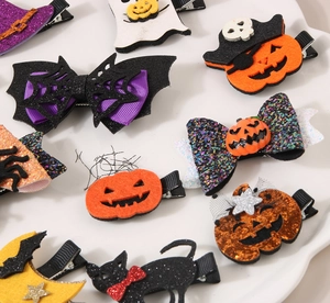Detailed flat lay of Halloween hair clips with pumpkin, ghost and bat wings designs