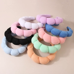 Macro detail of eight colorful padded bubble headbands in soft microfiber velvet fabric