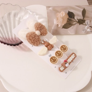 Détail d'un ensemble de barrettes brunes avec nœud en peluche et motifs d'ours