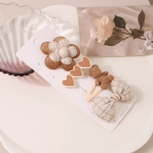 Vue détaillée d'un lot de 4 barrettes à cheveux avec fleurs en tissu et ours mignon