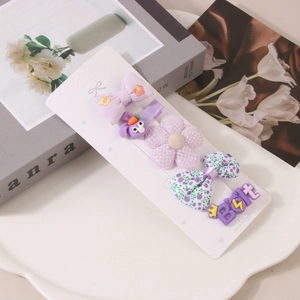 Detail eines fünfteiligen lila Haarspangen-Sets für Kinder mit Blumen und Hasen