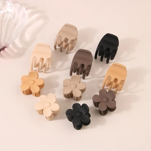 Macro detail of 10 matte hair claws in coffee tones including floral and wave designs