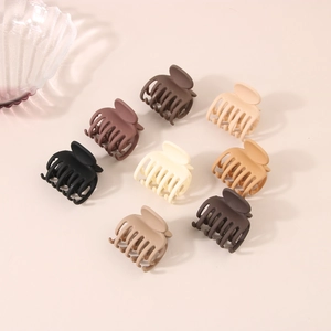Set of 8 matte 4cm hair claw clips in neutral earthy tones on pink background