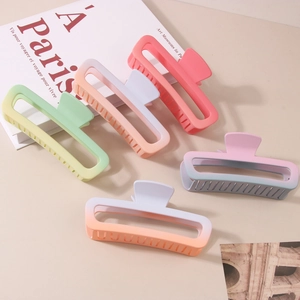 Macro detail of rectangle matte gradient large hair claws in assorted macaron colors
