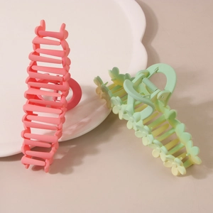 Matte flower hair claws in pink and gradient yellow-green on decorative plate