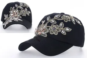 Detail of black baseball cap with rhinestone flower embroidery and gold silk accents