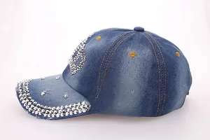 Detail of silver rhinestone S-letter and three rows of gems on blue denim baseball cap