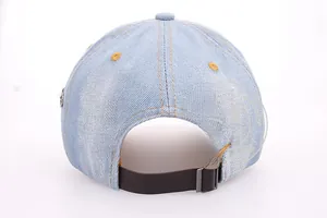Detail of light blue denim baseball cap back with brown leather strap and metal buckle