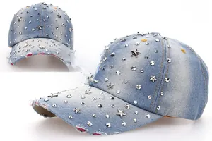 Detail of light blue denim baseball cap with silver star studs and distressed brim