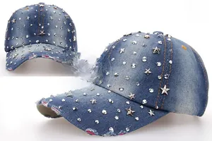 Detail of blue denim baseball cap with silver star studs and distressed frayed edges