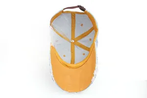 Detail view of denim baseball cap interior with yellow lining and brown leather strap