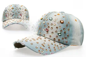 Détail d'une casquette de baseball en jean bleu clair avec strass colorés et rivets dorés