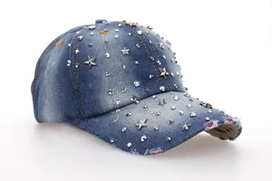 Detail of blue denim baseball cap featuring silver rivets and star studs with frayed brim
