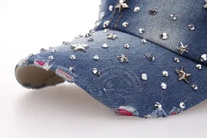 Close-up of distressed denim baseball cap with silver star rivets and rhinestone details