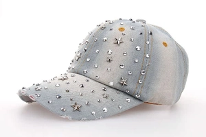 Star-studded light blue washed denim baseball cap with metallic rivets and distressed brim