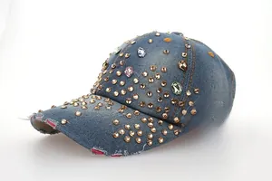 Détail d'une casquette en jean bleu avec strass multicolores et bordure effet usé
