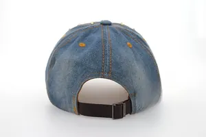 Détail de la sangle en cuir et des rivets dorés au dos de la casquette en denim bleu