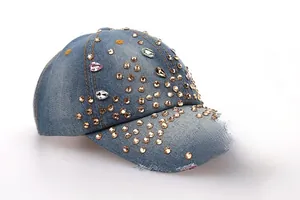 Détail de la casquette de baseball en jean bleu clair avec strass brillants et bords usés