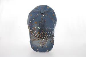 Détail d'une casquette de baseball en jean bleu avec strass et pierres précieuses