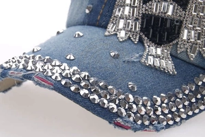 Detail of denim baseball cap with rhinestone owl pattern and distressed brim