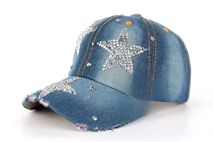Gros plan sur les motifs d'étoiles en strass et rivets sur une casquette en jean vieilli