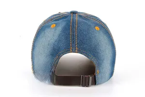Détail de la casquette en jean montrant la sangle réglable en cuir et les coutures oranges