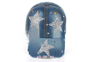 Détails des strass en étoile et bord usé sur casquette en jean bleu délavé