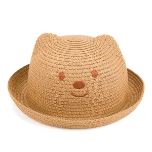 Détail montrant la texture de paille fine et la broderie ours sur le chapeau de soleil enfant