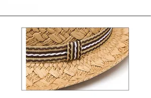Detail of woven straw hat featuring striped ribbon trim and white wave embroidery