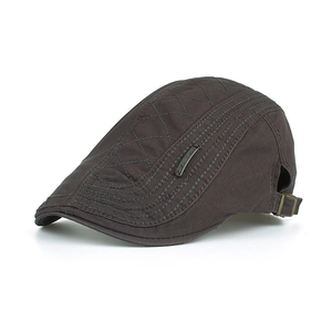 Détail de la texture matelassée et de la boucle métallique sur la casquette plate