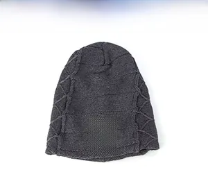 Detail of dark grey knit beanie showing cable knit pattern and gothic text patch