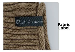 Detail of coffee brown knit beanie featuring a black woven fabric label with white text