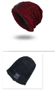 Detail view of wine red and black knitted beanie with thick fleece lining and label