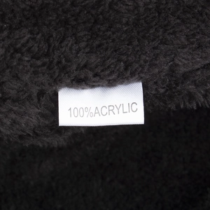 Close-up of black knit beanie with 100% acrylic fabric label showing texture and warmth
