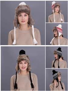Detail of winter trapper hat with pompom and ethnic patterns in red and black