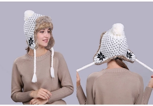 Close-up of winter knit trapper hat featuring snowflake patterns and plush faux fur lining