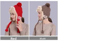 Close-up of winter snowflake ear-flap hat with plush lining and decorative pom-poms