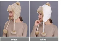 Detail view of beige and white winter knit trapper hats with thick plush lining and pompoms