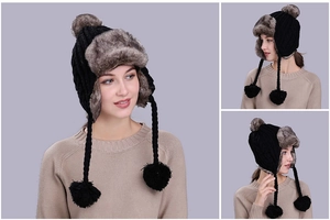Detailed view of black cable knit aviator hat with soft faux fox fur lining and pom poms
